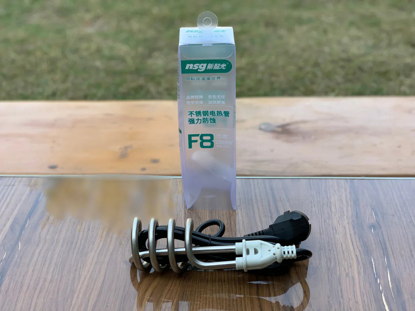 NSG F8 heating element on a wooden surface with a blurred green background